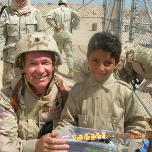 6. Author with Iraqi child during Gifts for Children distribution of clothing, educational supplies, and toys at Camp Bucca 2006.